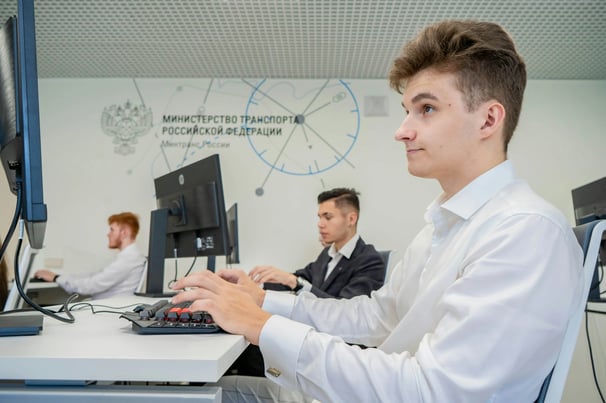 Blonde male student eagerly focused in a classroom on the computer