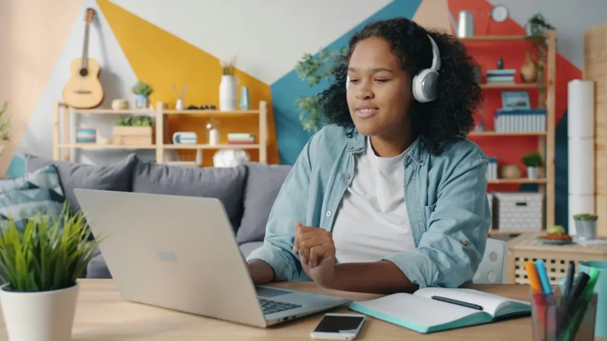K-12 student with headphones on computer working on a project.